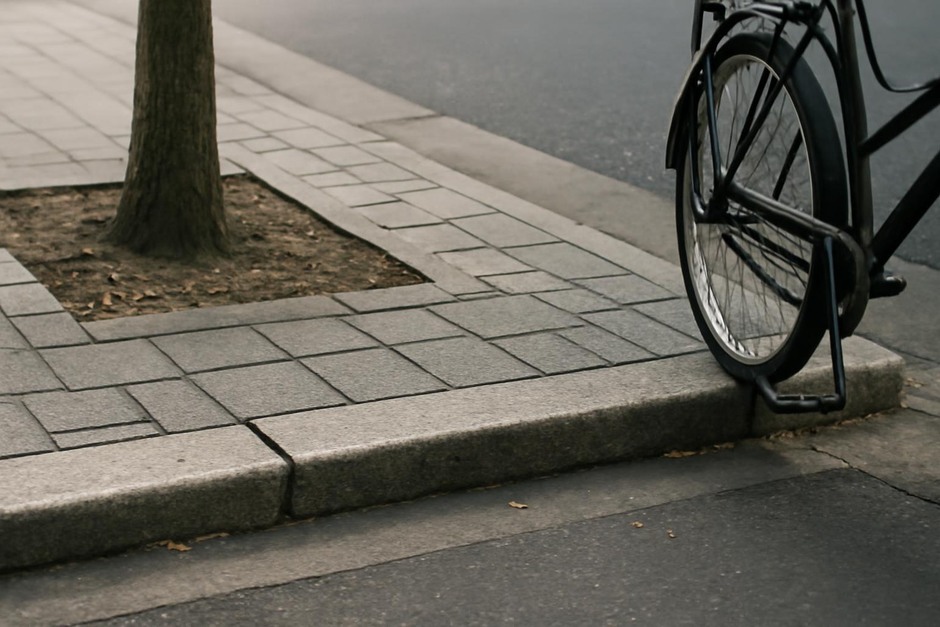 Close-up of kerb, paving, tree pit and parked bicycle on a quiet urban lane